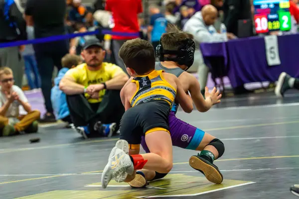 A young Rangers wrestler drives an opponent forward on the mat
