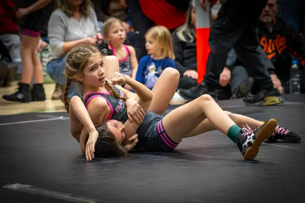 A Rangers wrestler looks up while working an opponent on the mat